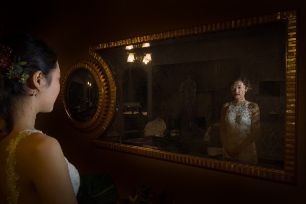 Bride in wedding dress looking in mirror